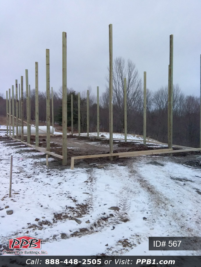 Poles set for long garage with two-tone siding.