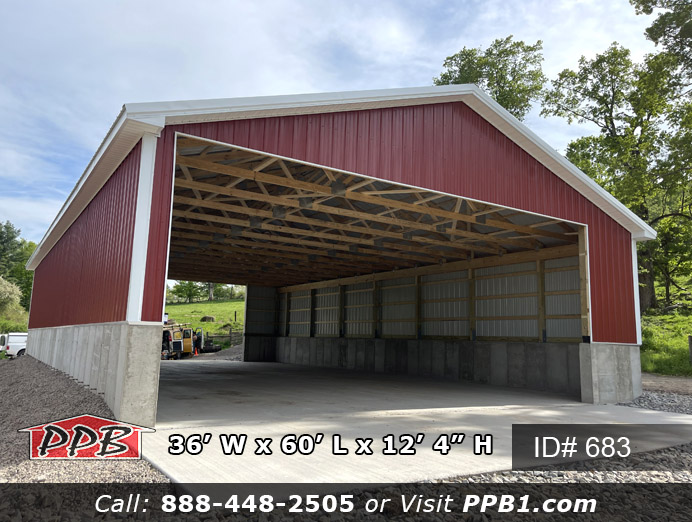 This drive through garage is thirty-six feet wide by sixty feet long with two thirty feet wide by twelve feet high openings on each end. The siding color is red with a white roof and trim color as well. It has a four feet concrete wall that the building is built on making it a total of twelve feet tall.